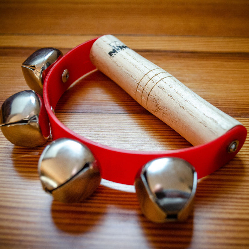 NINO962 rouge avec quatre grelots sur une surface en bois