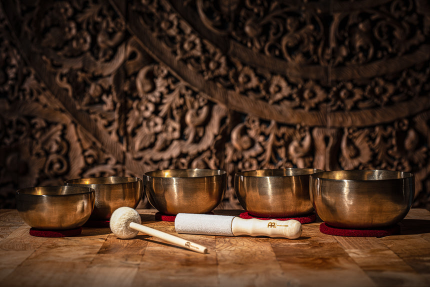 Maillet résonant Meinl Sonic Energy SB-RM-LE en cuir suédé, 20,1 cm – à côté de bols chantants.