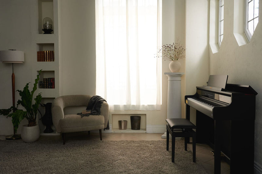 Casio AP-750BK digital piano in black – side view in a living room with an armchair.