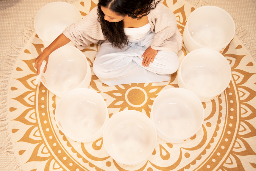 Set de sept bols chantants en cristal MEINL PCSBSETCHA blancs givrés avec symboles planétaires dorés – vue rapprochée de dessus d’un bol chantant joué.